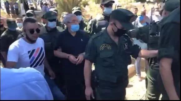 Ouyahia assiste menotté à l'enterrement de son frère (Vidéo)